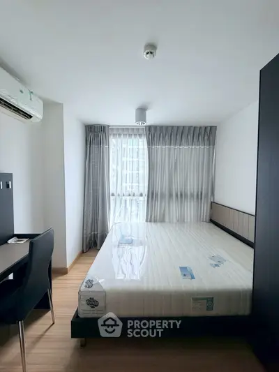 Modern bedroom with large window and minimalist furniture in a bright apartment.