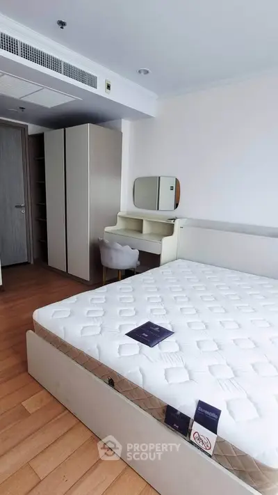 Spacious bedroom with modern furniture and ample storage in a stylish apartment.