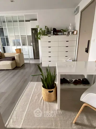 Modern living room with sleek furniture and indoor plants, featuring a stylish storage unit.
