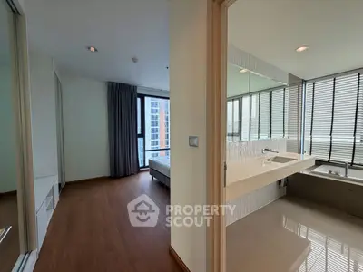 Spacious modern bedroom with ensuite bathroom featuring large windows and elegant design.