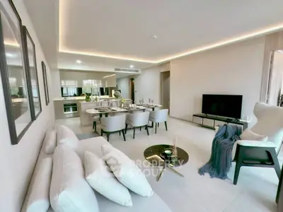 Spacious modern living room with open kitchen and elegant dining area, perfect for entertaining.