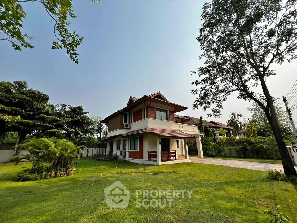 Charming two-story house with lush green lawn and trees, perfect for family living.