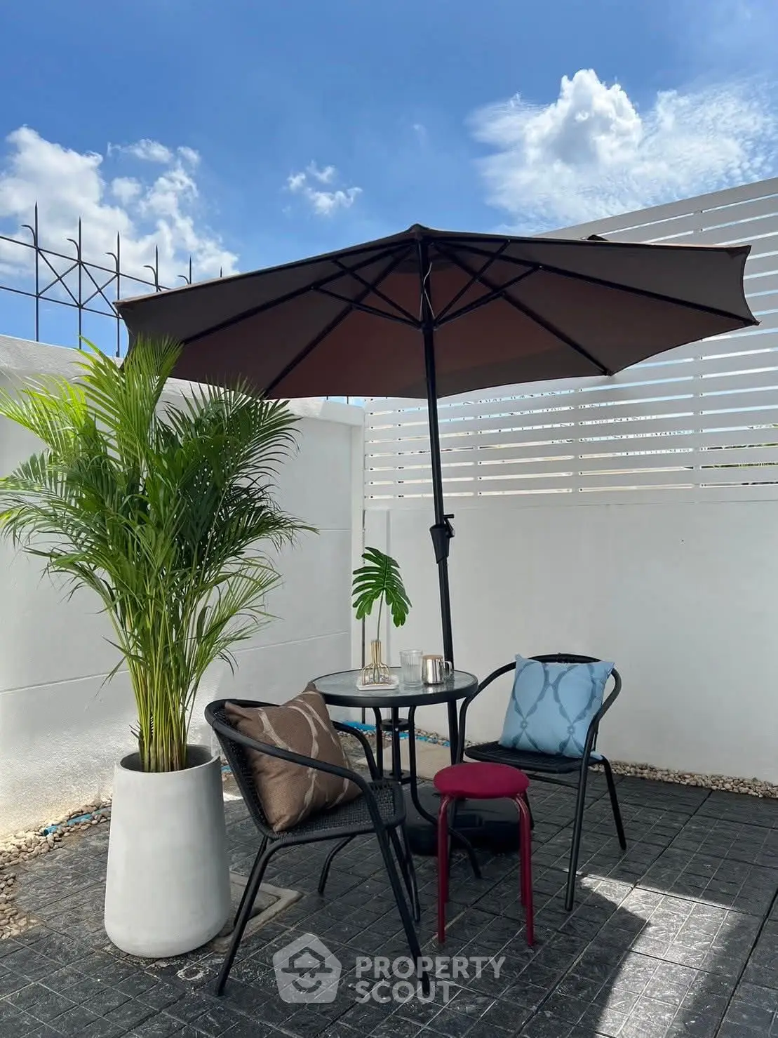 Charming outdoor patio with seating and umbrella, perfect for relaxation.