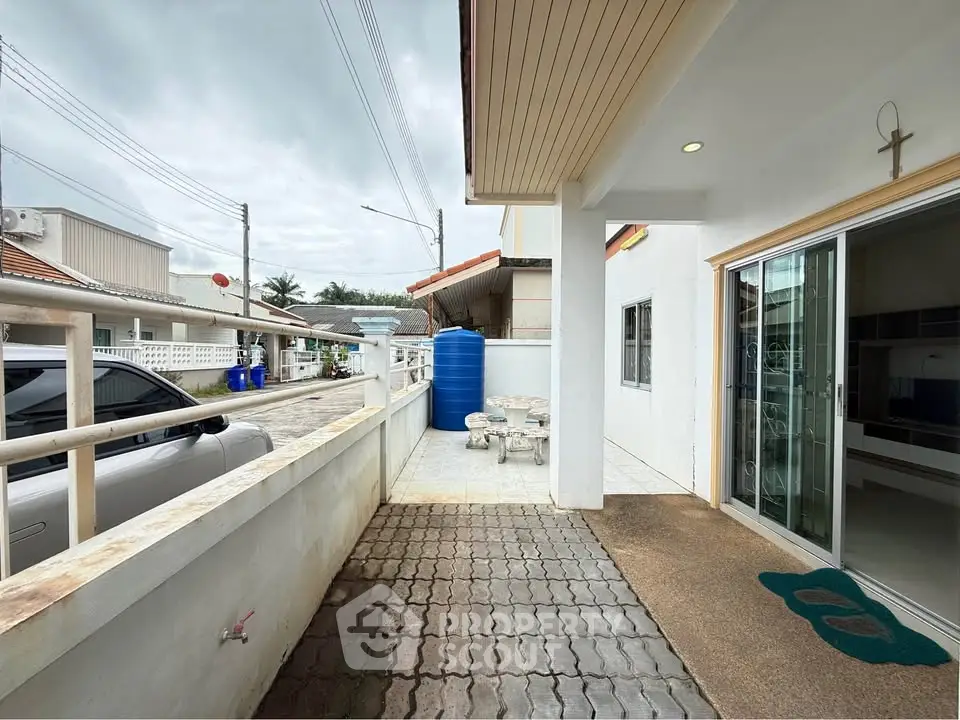 Charming outdoor patio area with modern sliding glass doors and spacious seating, perfect for relaxation.
