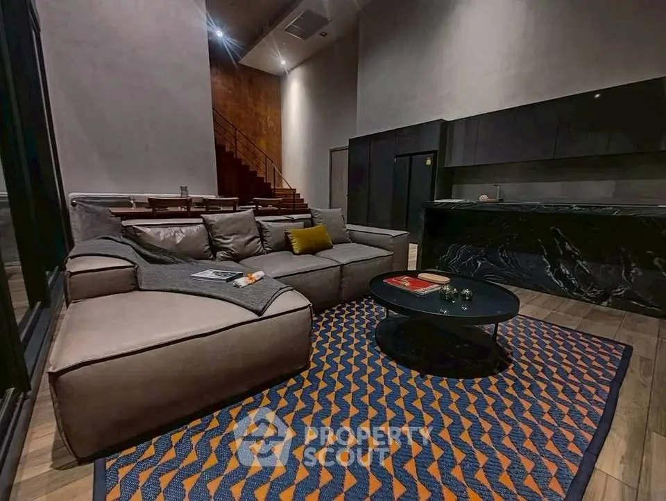 Luxurious modern living room with stylish furniture and open kitchen layout.