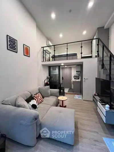 Modern loft apartment with stylish living room and mezzanine bedroom, featuring sleek design and cozy ambiance.