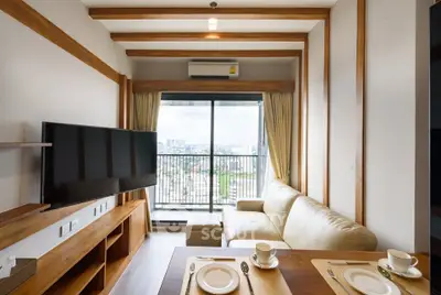 Modern living room with large TV and balcony view in stylish apartment
