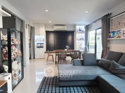 Spacious modern living room with cozy seating and dining area, featuring stylish decor and ample natural light.