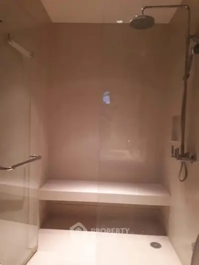 Modern bathroom with sleek shower design and built-in bench seating.