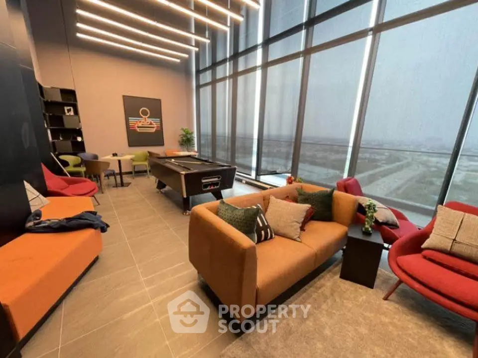 Luxurious modern living room with floor-to-ceiling windows and stylish furniture, offering a stunning view.