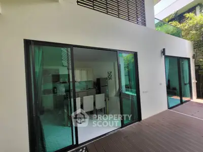 Modern home with spacious patio and glass sliding doors leading to a stylish dining area.