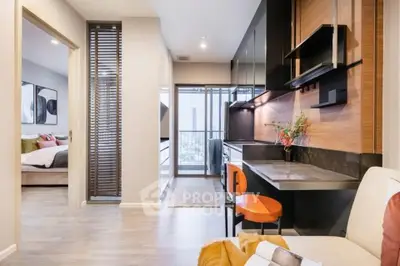 Modern apartment interior with open kitchen and cozy living area, featuring stylish decor and city view.