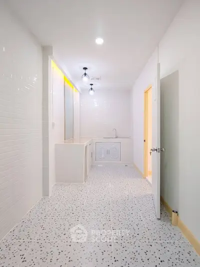 Spacious white bathroom with modern fixtures and terrazzo flooring