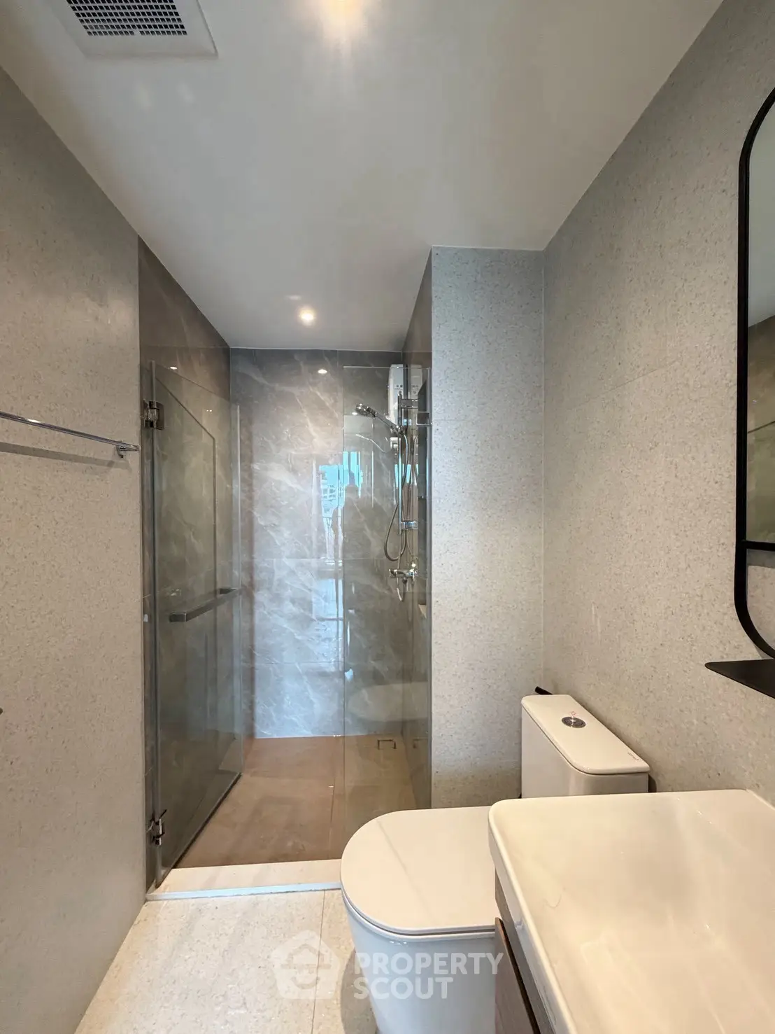 Modern bathroom with glass shower and sleek fixtures in a contemporary apartment.