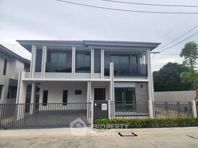 Modern two-story house with sleek design and spacious driveway in a serene neighborhood.