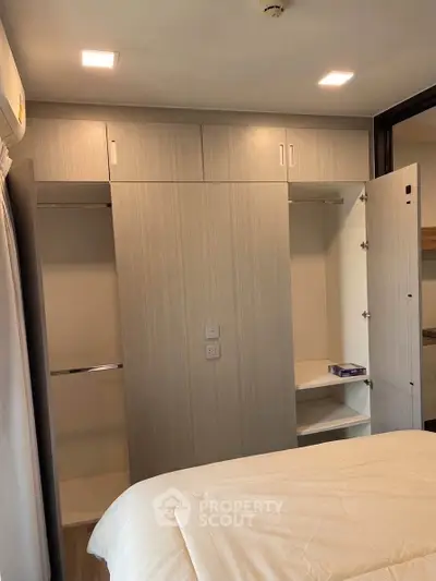 Modern bedroom with built-in wardrobe and cozy lighting, perfect for comfortable living.