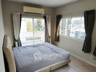 Spacious bedroom with balcony access and large windows for natural light