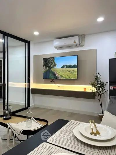 Modern living room with wall-mounted TV and air conditioning, featuring sleek design and cozy ambiance.