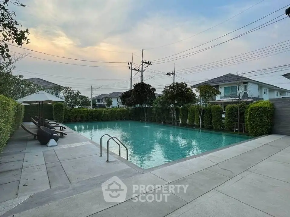 Luxurious residential pool area with serene ambiance and lush greenery