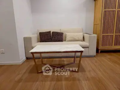 Modern living room with stylish sofa and elegant coffee table on wooden flooring.