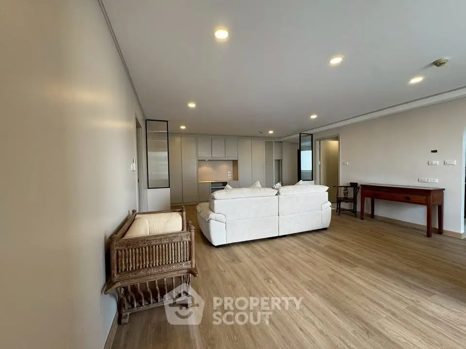 Spacious modern living room with elegant wooden flooring and cozy seating area.