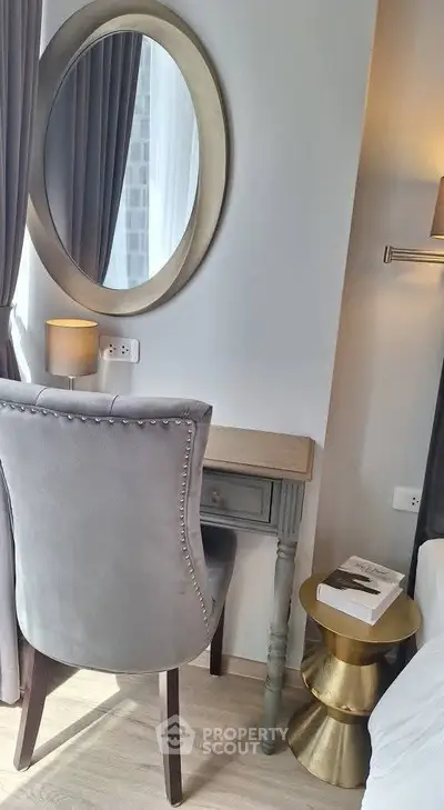 Elegant bedroom corner with stylish chair, round mirror, and side table, perfect for a cozy reading nook.