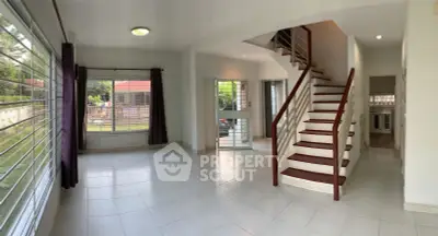 Spacious living room with modern staircase and large windows