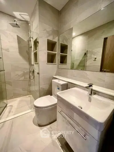 Modern bathroom with sleek fixtures and spacious shower in a contemporary apartment.