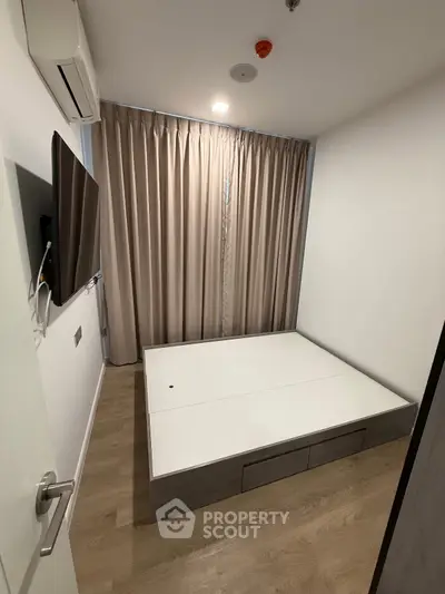 Modern minimalist bedroom with platform bed and wall-mounted TV