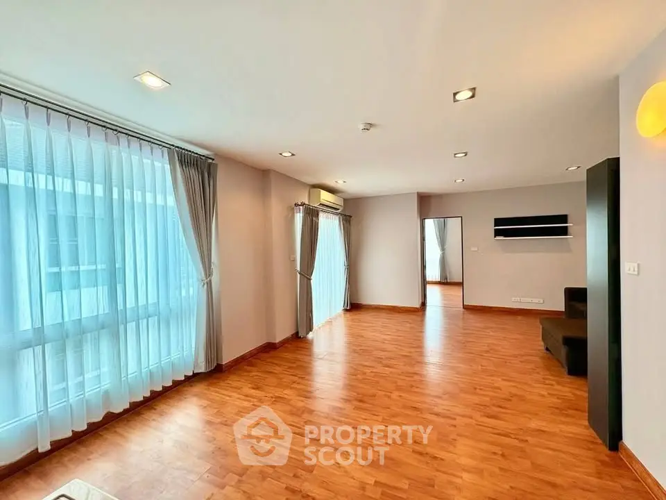 Spacious modern living room with wooden flooring and large windows