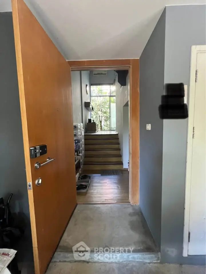 Inviting entrance with wooden door leading to a stylish interior with natural light and modern design.