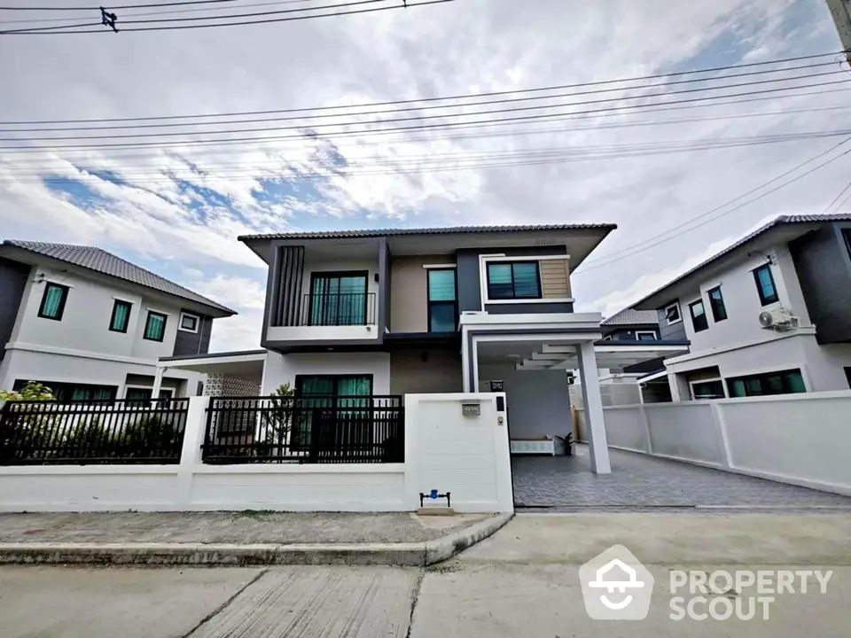 Modern two-story house with sleek design and spacious driveway in suburban neighborhood.