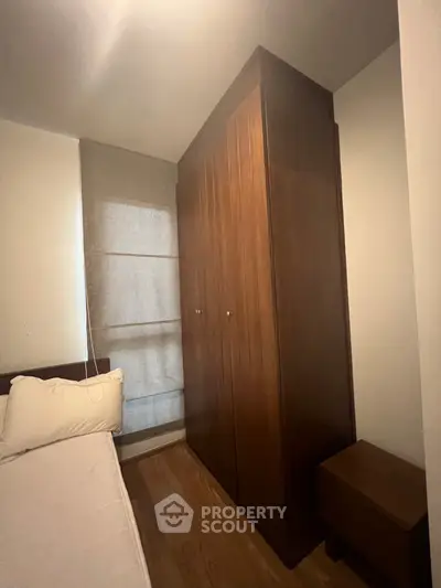 Cozy bedroom with wooden wardrobe and soft lighting, perfect for a restful retreat.