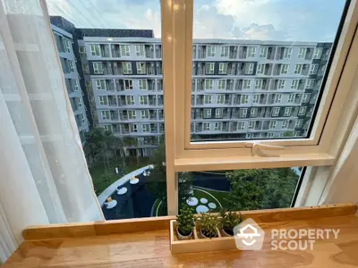 Modern apartment view with lush garden and pool from window