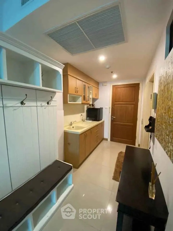 Charming entryway with built-in storage and cozy kitchenette in modern apartment.