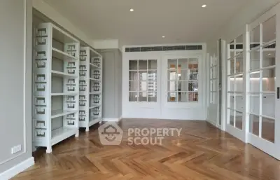 Spacious living room with elegant parquet flooring and built-in shelving