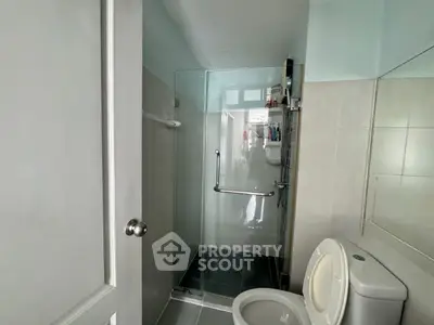 Modern bathroom with glass shower enclosure and tiled walls