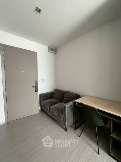 Modern minimalist living room with sleek sofa and compact workspace