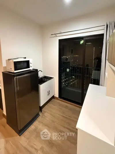 Modern kitchen with sleek appliances and balcony view in a stylish apartment.