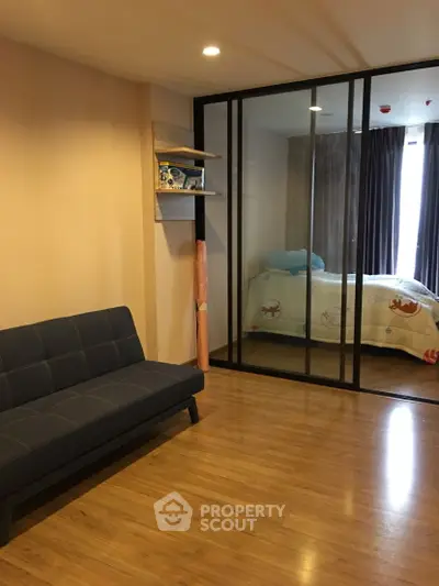 Modern apartment with glass partitioned bedroom and cozy living area.