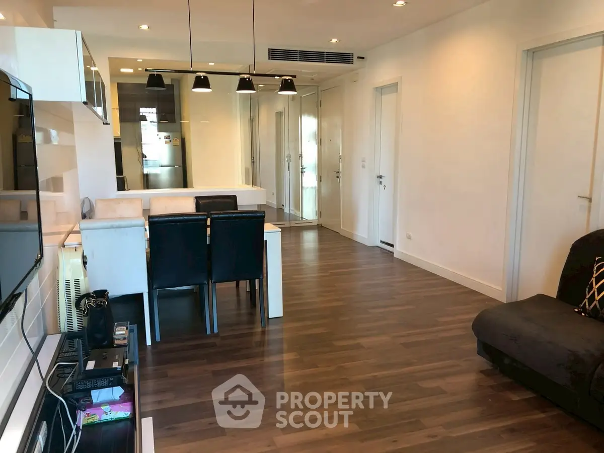 Modern living room with sleek dining area and hardwood flooring