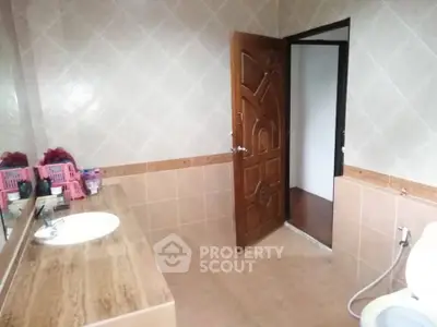 Spacious bathroom with elegant wooden door and modern fixtures