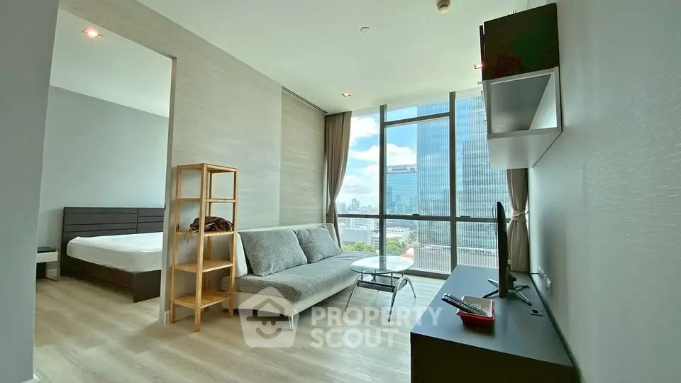 Modern apartment with city view, featuring a cozy living area and bedroom with large windows.