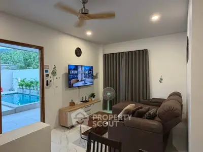 Modern living room with pool view, cozy seating, and stylish decor