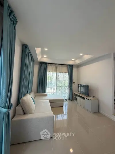 Spacious living room with modern decor and large windows for natural light.
