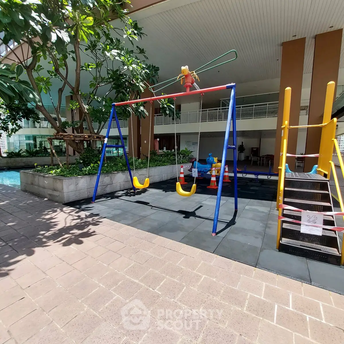 Luxurious residential building with modern playground and lush greenery, perfect for family living.