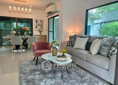Stylish living room with modern decor and dining area, featuring plush seating and elegant lighting.