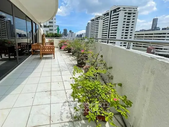 Spacious balcony with city view and potted plants in modern apartment
