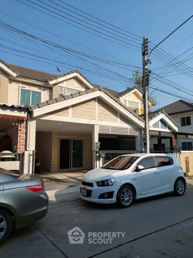 Charming suburban house with driveway and parked cars in a peaceful neighborhood.