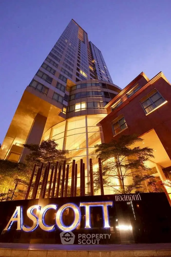Stunning high-rise building exterior with modern architectural design and illuminated signage at dusk.